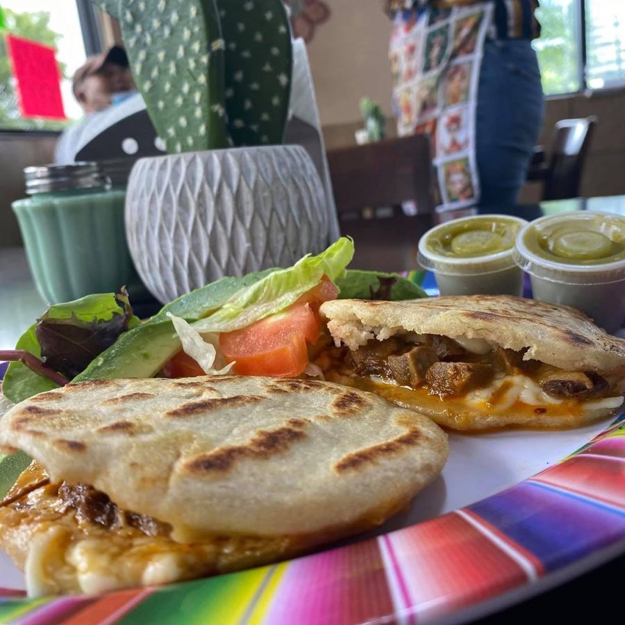 Grilled handmade masa stuffed with meat and melted cheese, with green salsa